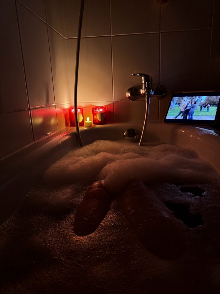 a bathtub filled with foam next to a tv