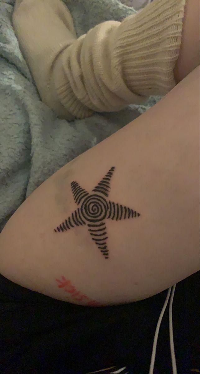 a person with a tattoo on their arm that has an image of a star in the middle