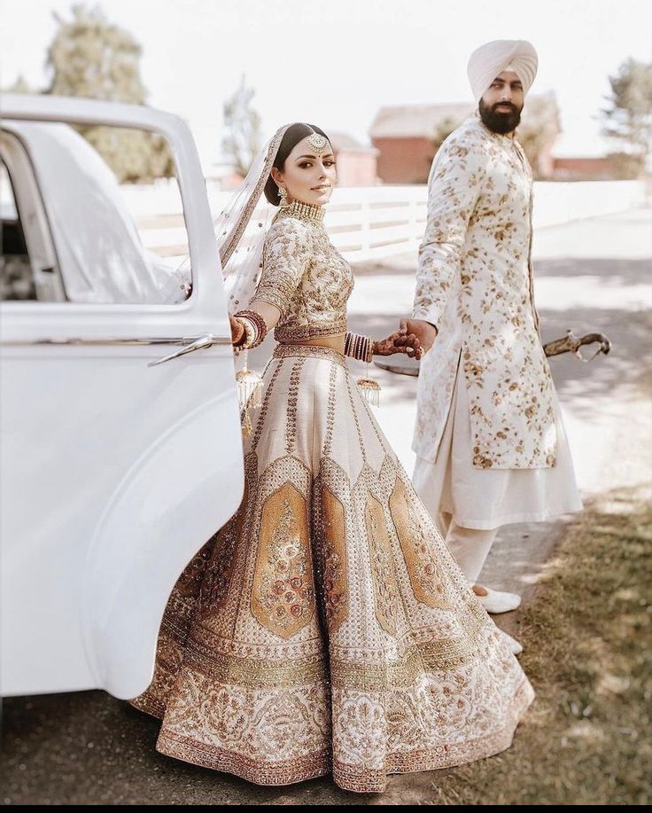 a man and woman standing next to a white car