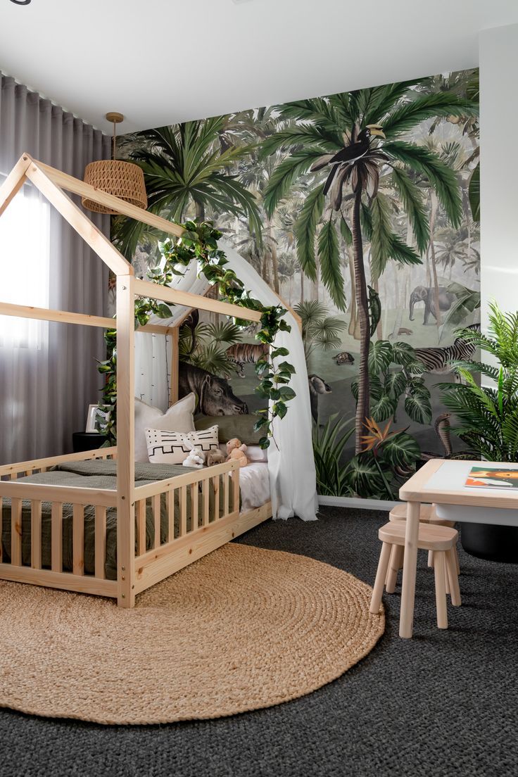 a child's bedroom with a jungle theme wallpaper