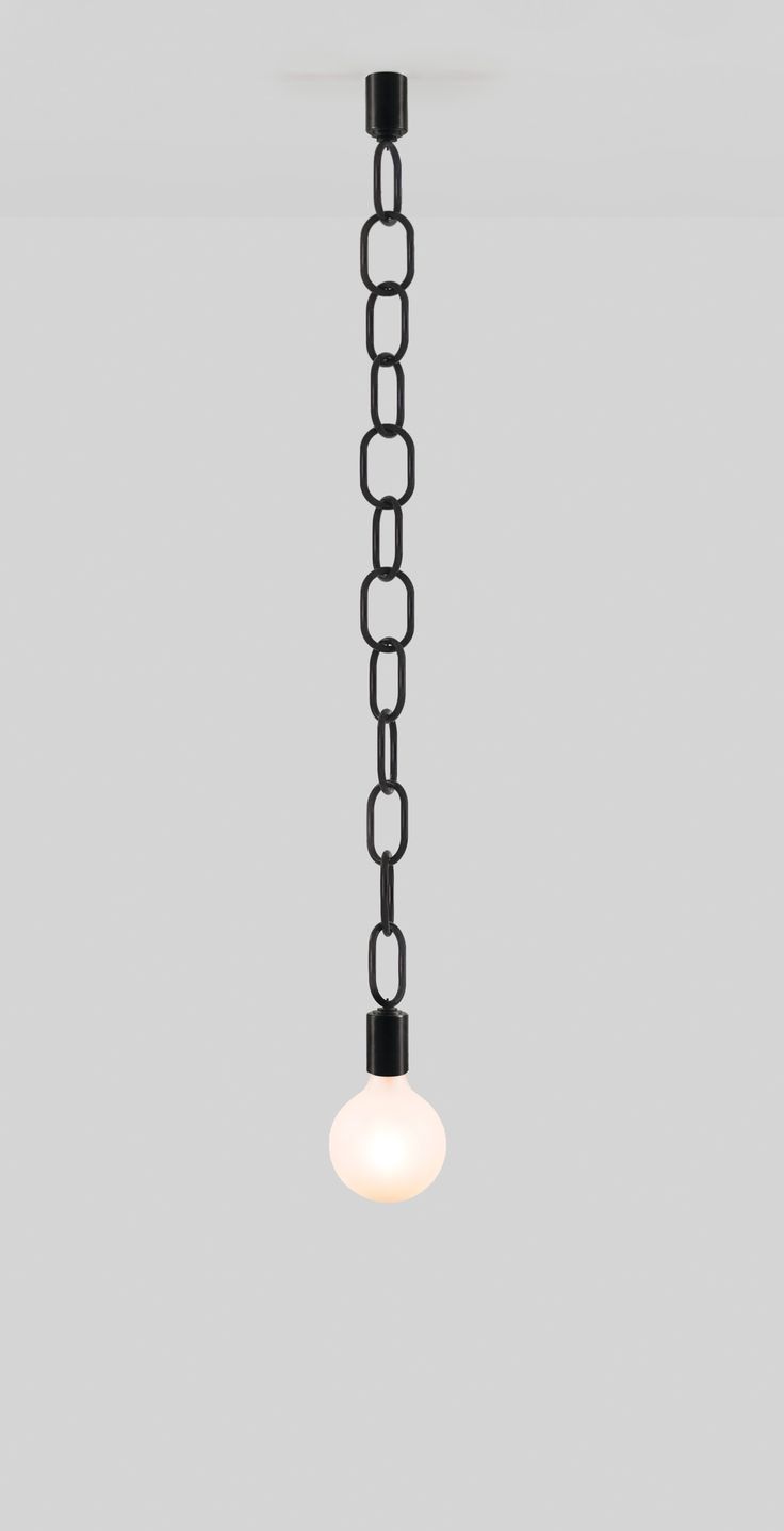 a light that is hanging from a chain on the ceiling in a room with gray walls and flooring