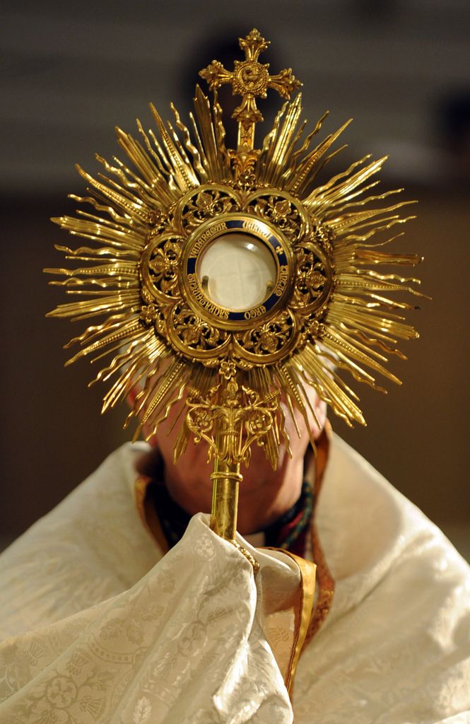 a close up of a person wearing a gold crown and holding a cross in his hand