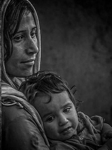 a black and white photo of a woman holding a child