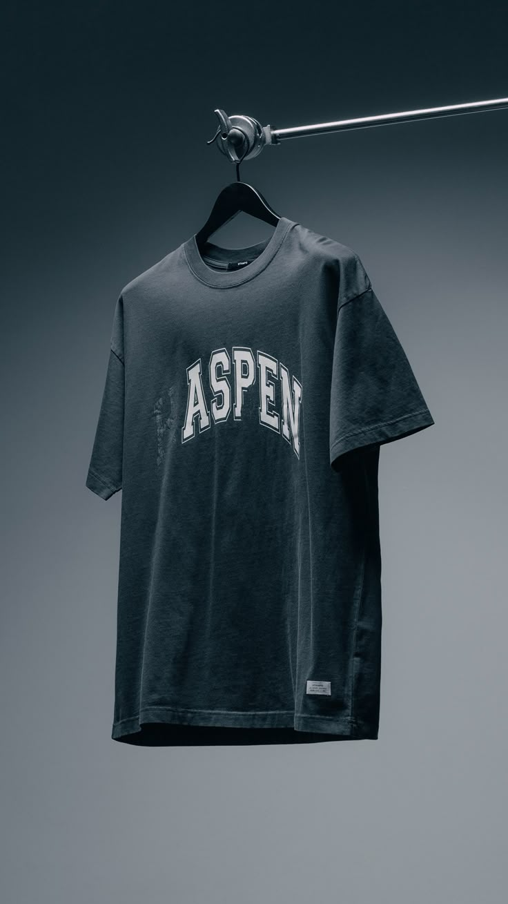 a t - shirt hanging on a clothes line with the word aspen printed on it