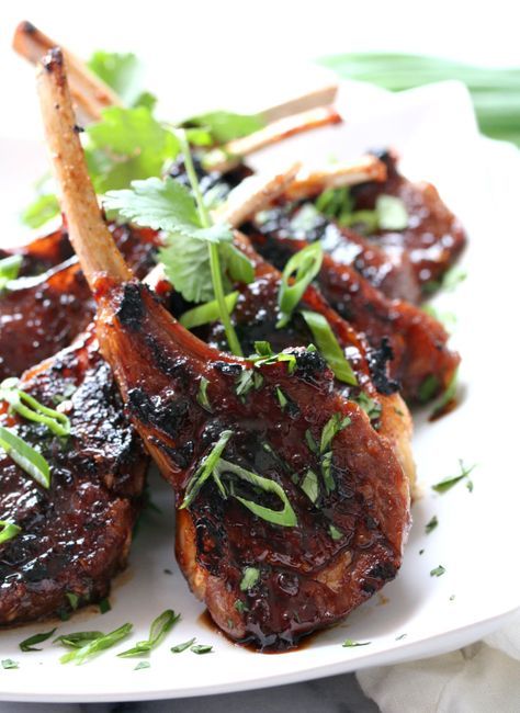 grilled pork chops on a white plate with garnish