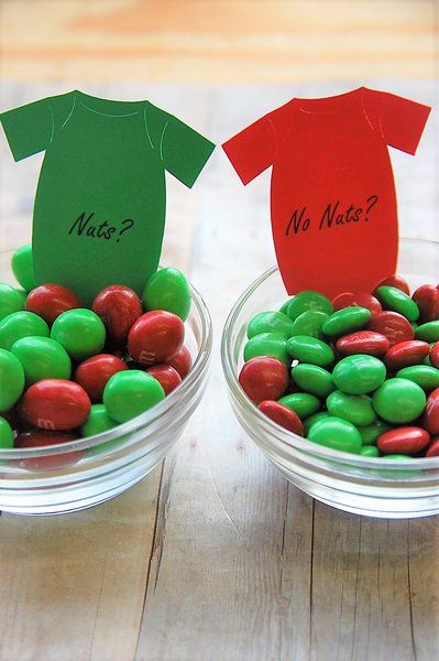 two bowls filled with green and red candies next to each other on top of a wooden table