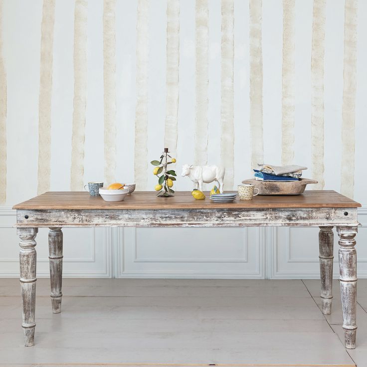 a wooden table with two bowls on it in front of a striped wallpapered background