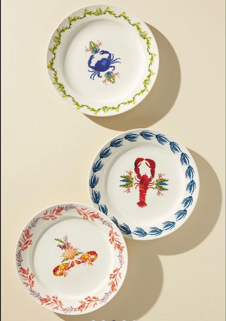 three plates with lobster designs on them sitting next to each other in the same pattern