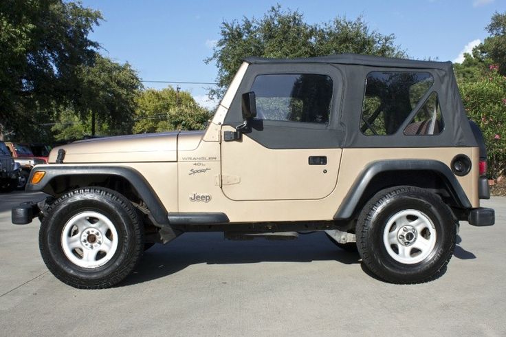 a tan jeep parked in a parking lot