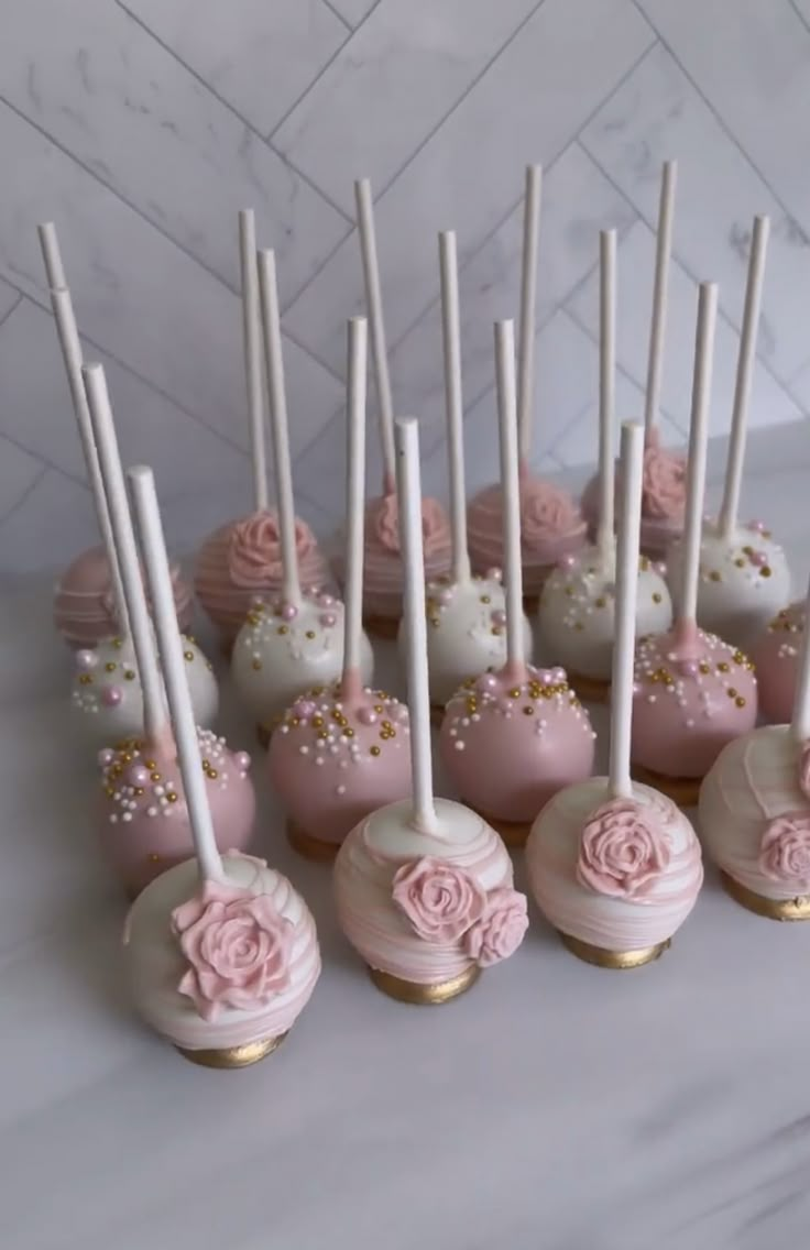 pink and white cake pops with flowers on them