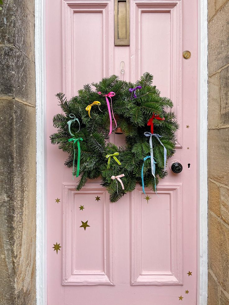 a pink door with a wreath on it