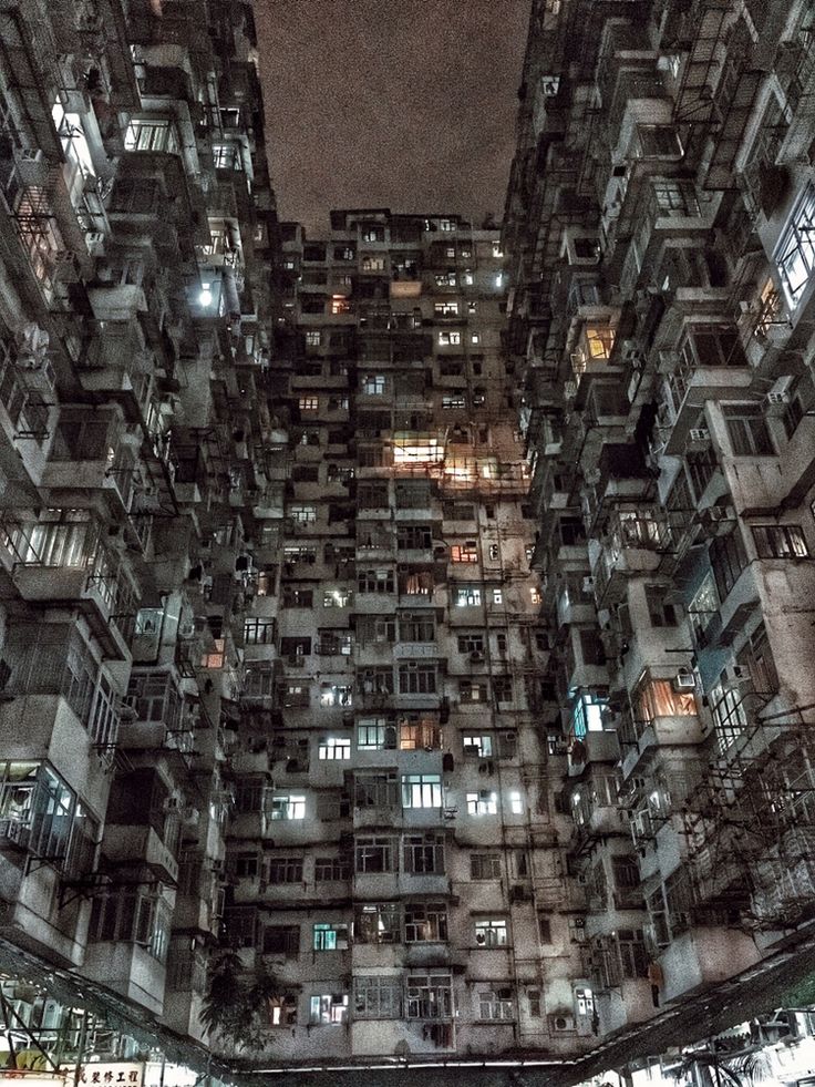 an apartment building at night with lots of windows and balconies on the sides