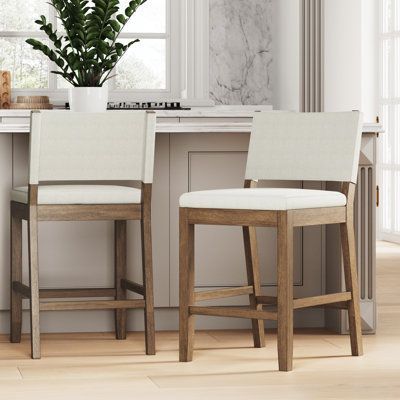 two white chairs sitting at a kitchen counter