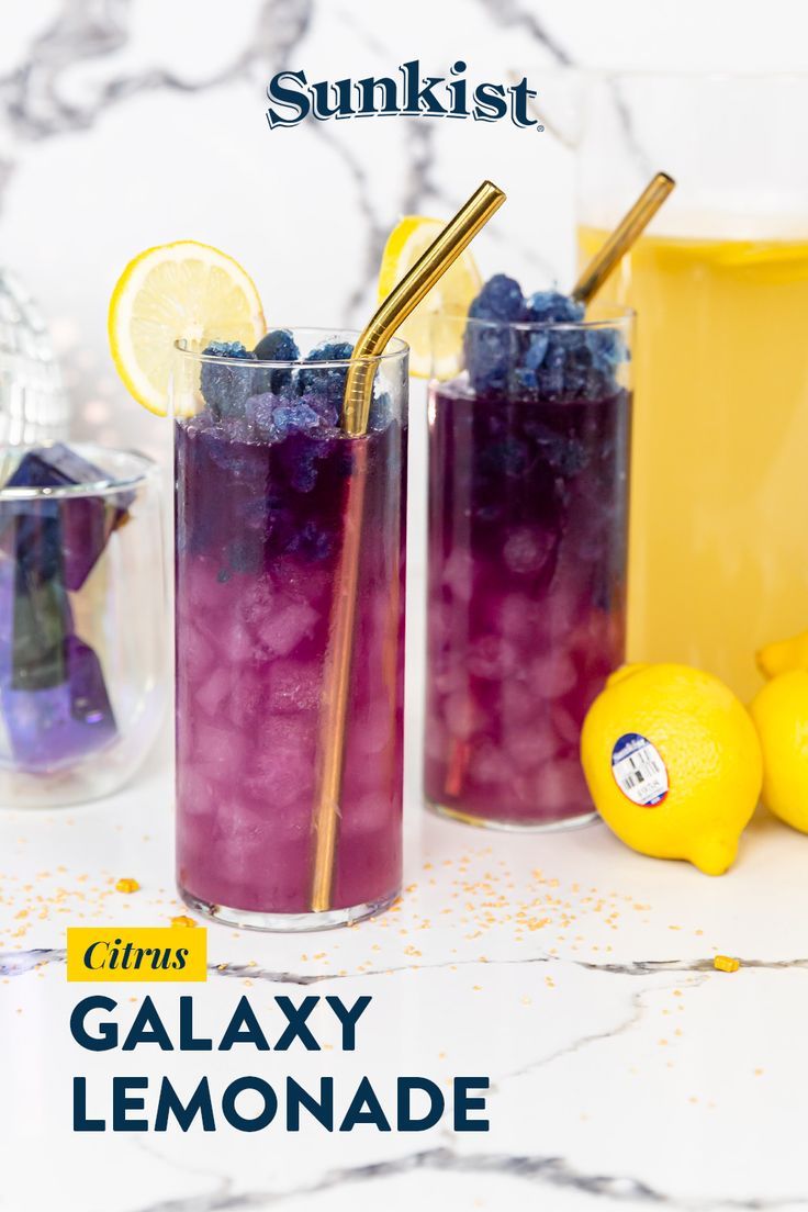 two glasses filled with blueberries and lemonade on top of a marble countertop