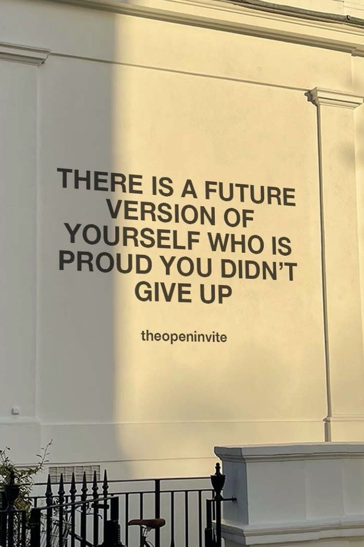 there is a sign on the side of a building that says, there is a future version of yourself who is proud you didn't give up