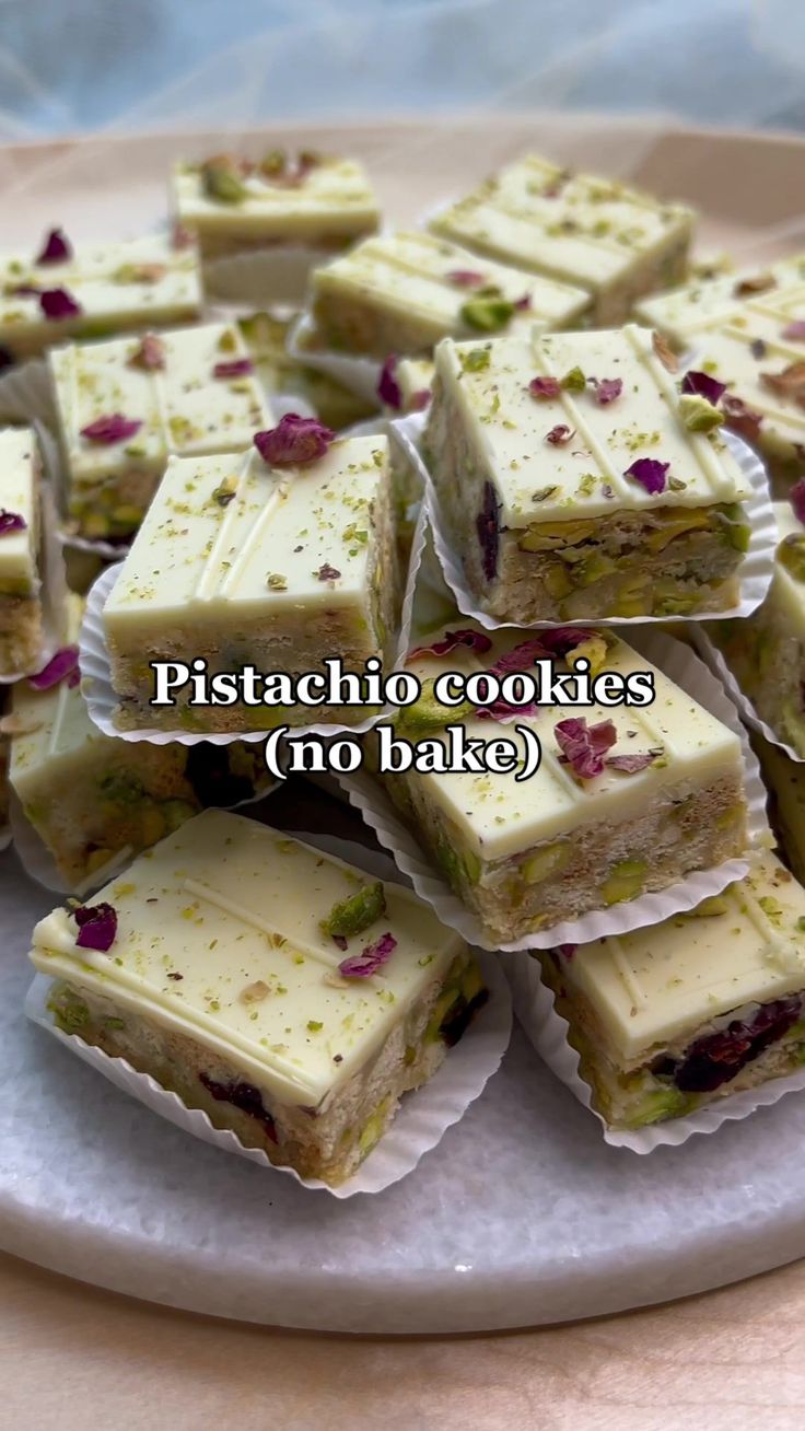 there are many pieces of cake on the plate with words above it that say, pistachio cookies no bake