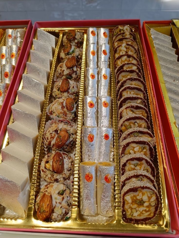 there are many different types of food in the trays on this table, including rolls and crackers