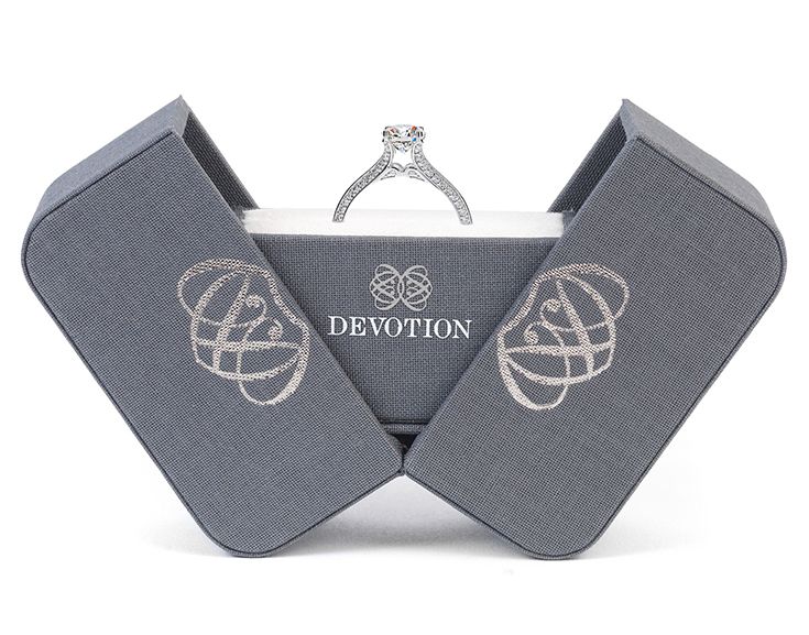 a diamond ring sits on top of a box with the word'devont'in it