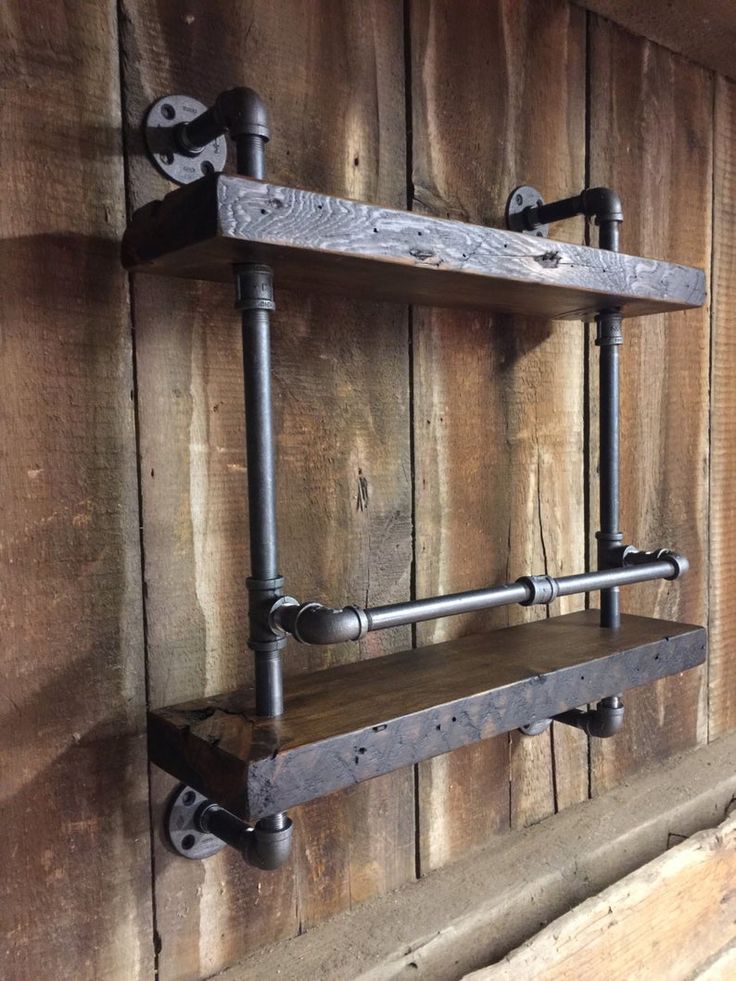 two metal pipes are attached to the wall with wood planks and pipe shelves on each side