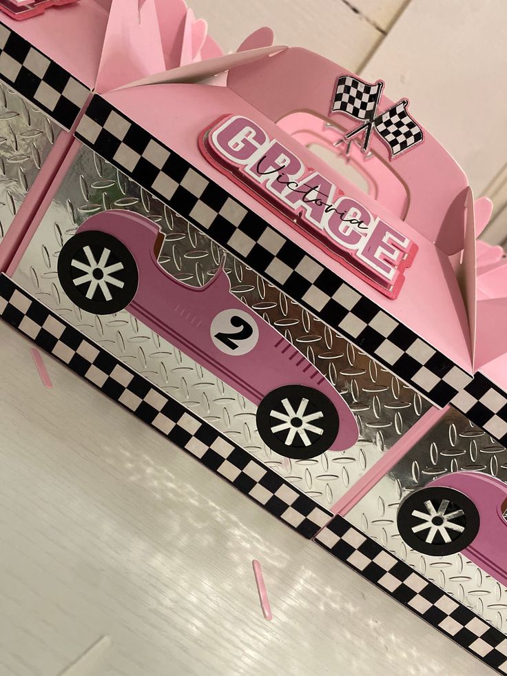 two pink boxes with black and white checkered designs on the sides, one is empty