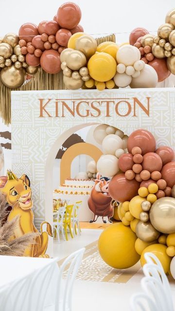 a table topped with balloons and animals next to a sign that says kingston on it