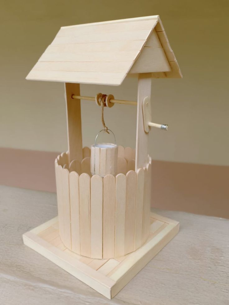 a small wooden birdhouse with a key in it