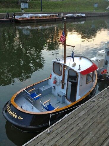 the small boat is docked at the dock by the water's edge and has an american flag on it