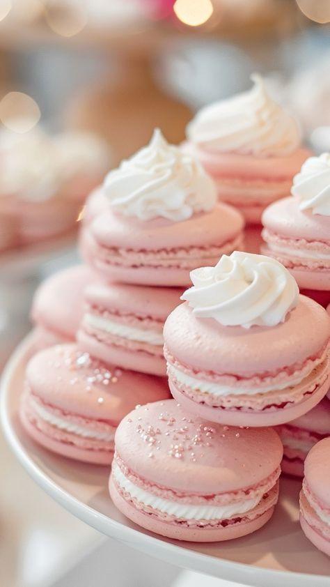 pink macaroons with white frosting on a plate