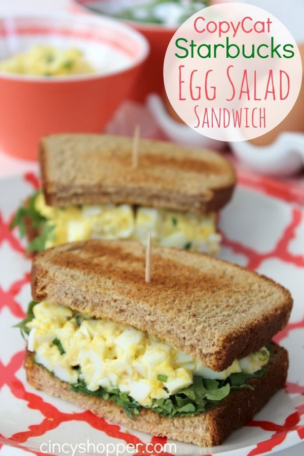 an egg salad sandwich is cut in half and sitting on a red and white plate