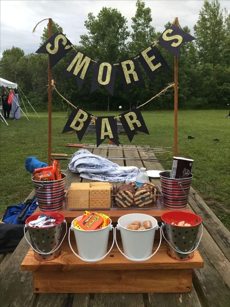 an outdoor bar set up with buckets and food