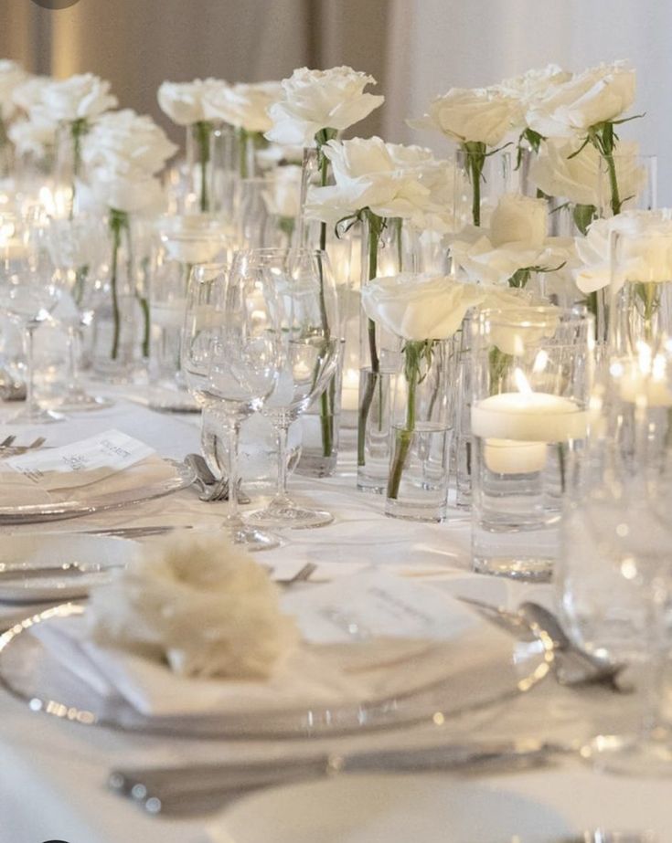 the table is set with white flowers and silverware for an elegant dinnereon party