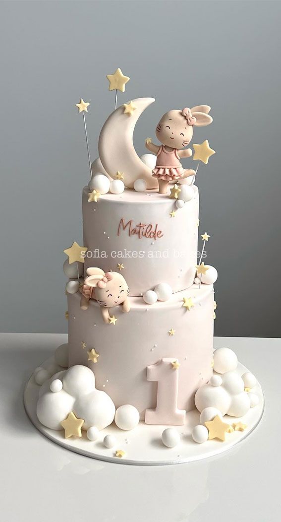 a white cake decorated with stars and a rabbit on top