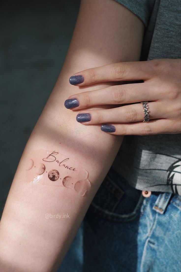 a woman's arm with a small tattoo on it