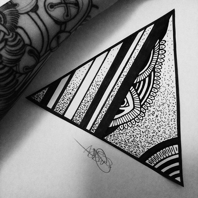 a black and white photo of a triangle tattoo