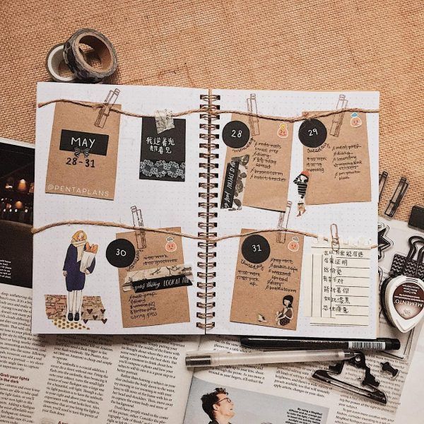 an open planner book with clothes pins and magnets attached to it, on top of a newspaper