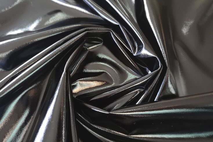 an image of shiny black material that looks like it has been coated with metallic foil