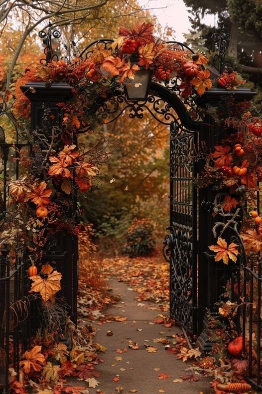 an iron gate with autumn leaves on it