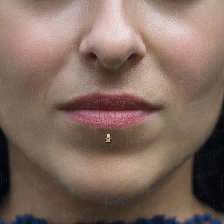 a close up of a woman's face with a nose piercing