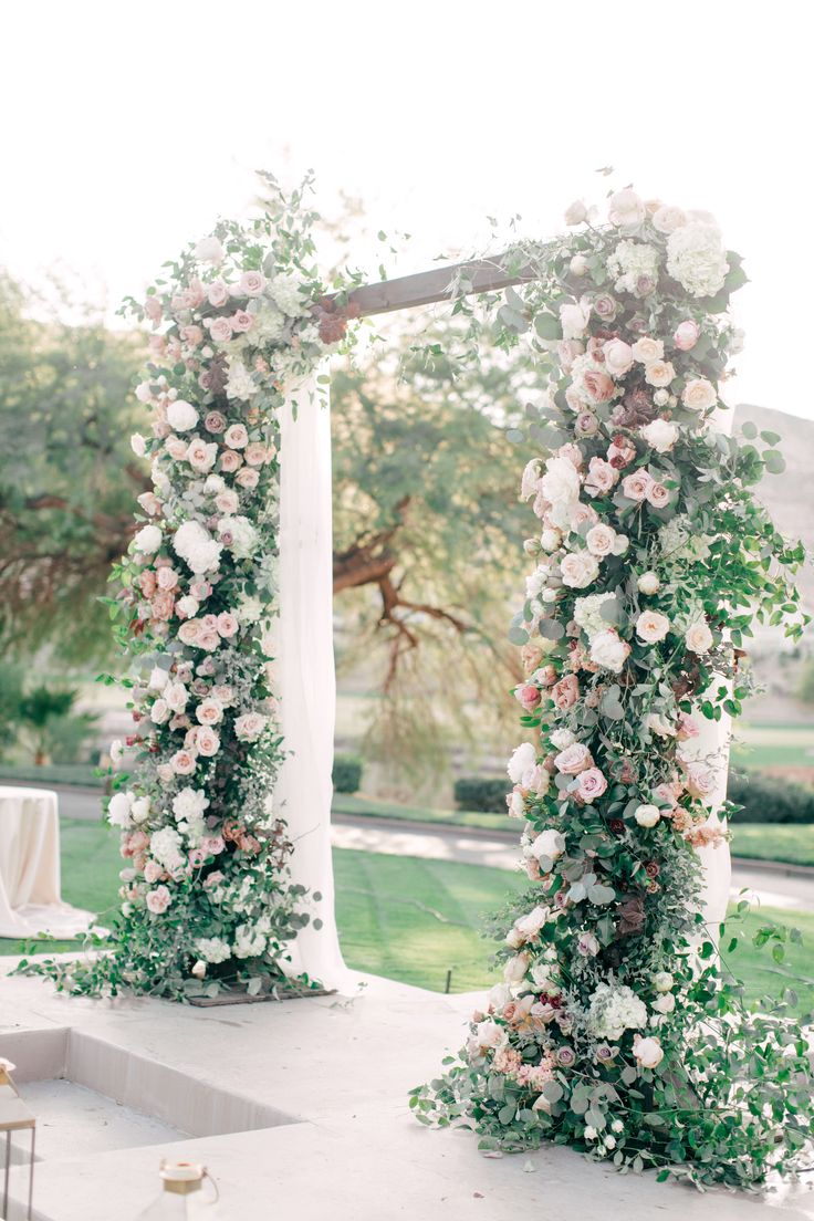 an outdoor ceremony with flowers and greenery