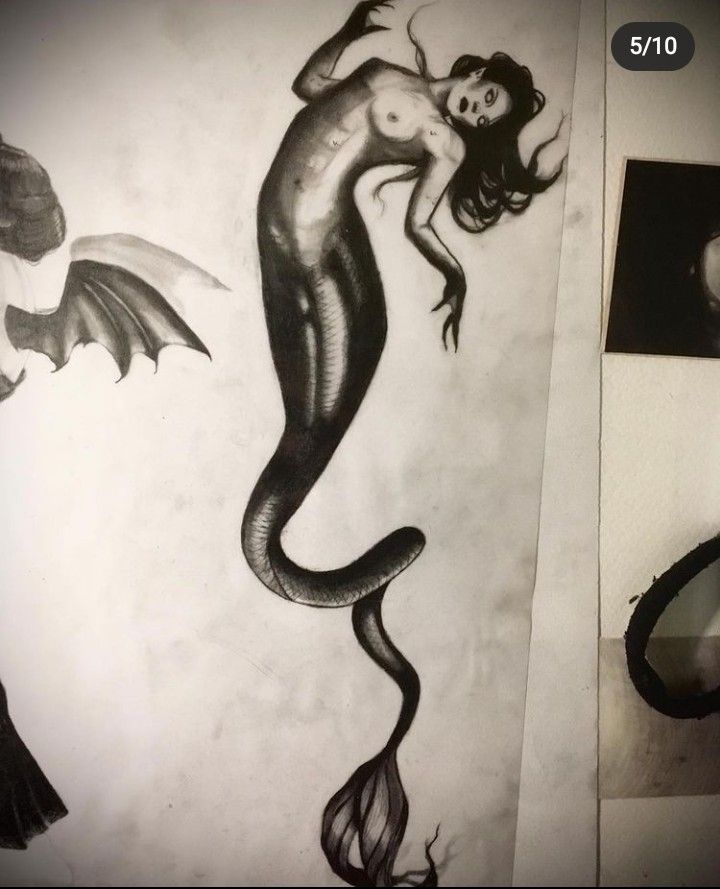 a black and white photo of a drawing of a mermaid