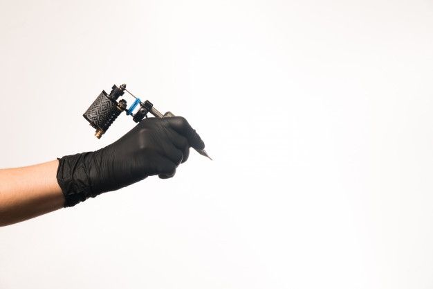 a person wearing black gloves holding a small device