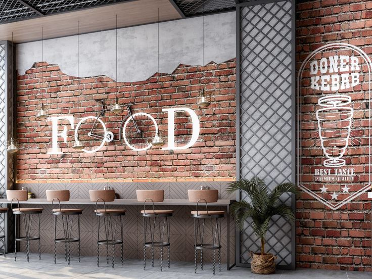 an empty restaurant with brick walls and wooden tables in front of the wall that reads food