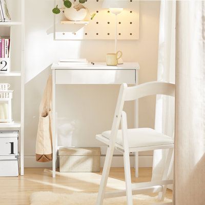 a white desk and chair in front of a book shelf with books on top of it