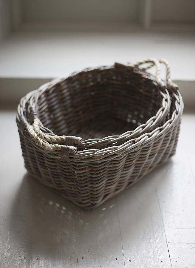 a wicker basket sitting on the floor in front of a window