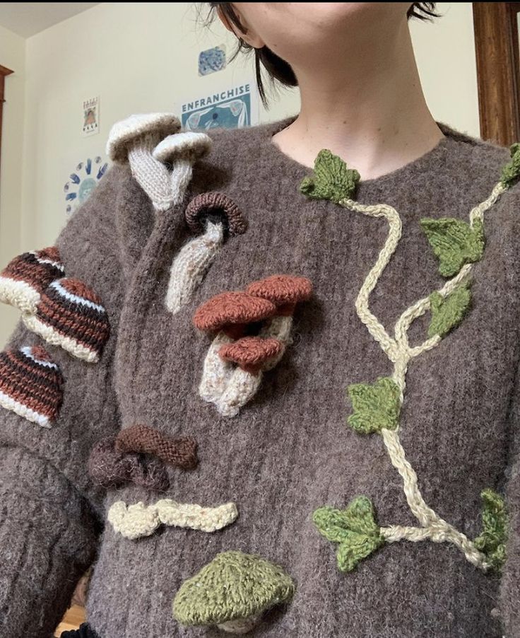 a woman wearing a sweater with leaves on it