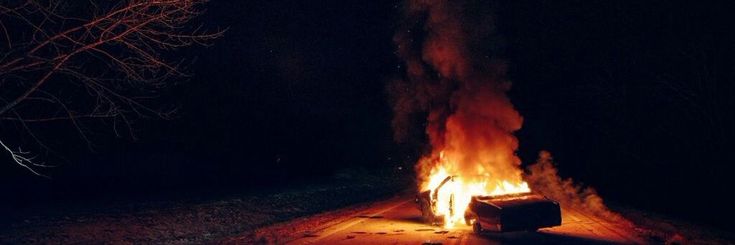 a fire burning in the middle of a field at night