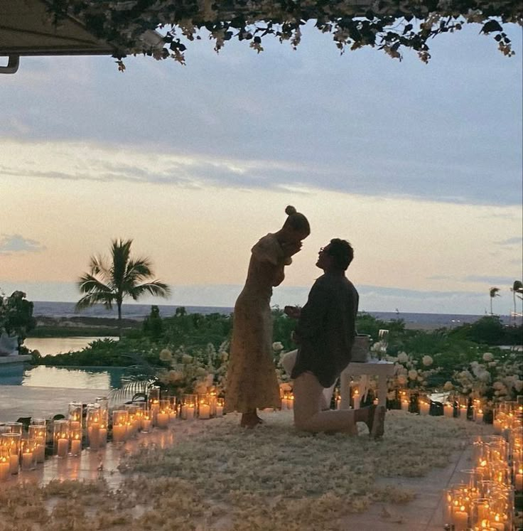 a man and woman standing next to each other in front of a lot of candles