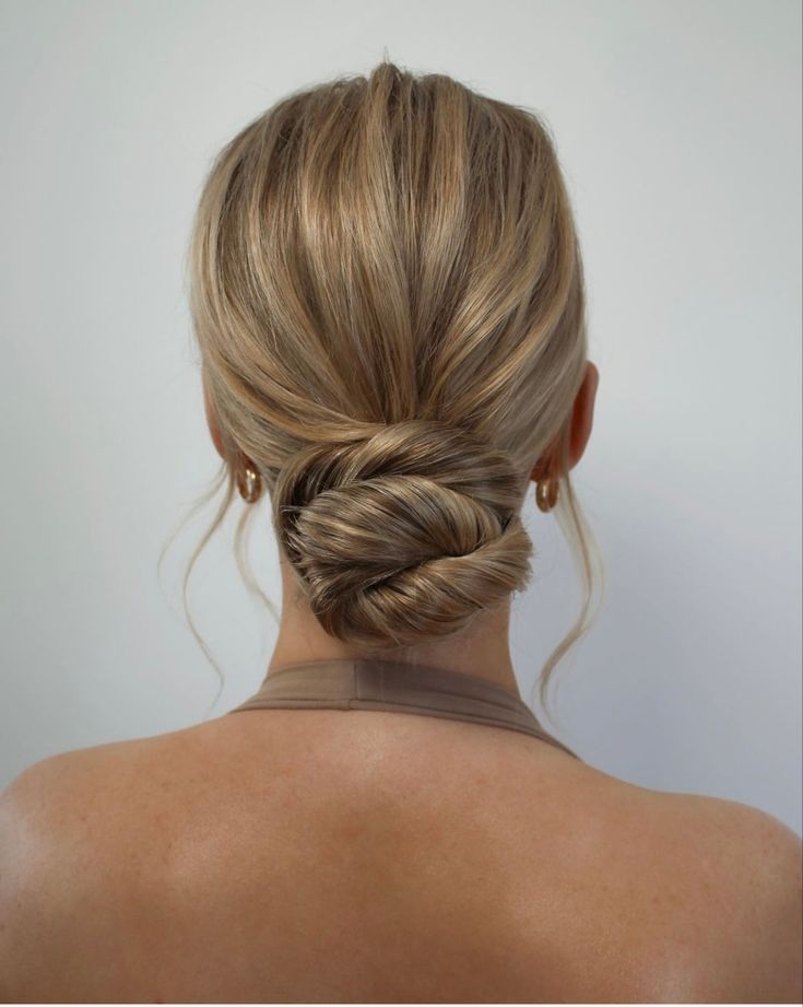 a woman with blonde hair in a low bun