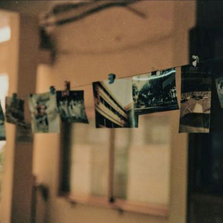 several photographs hanging on a line in front of a window