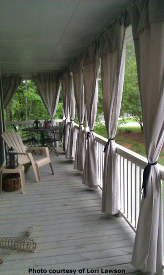 an outdoor covered porch with chairs and curtains